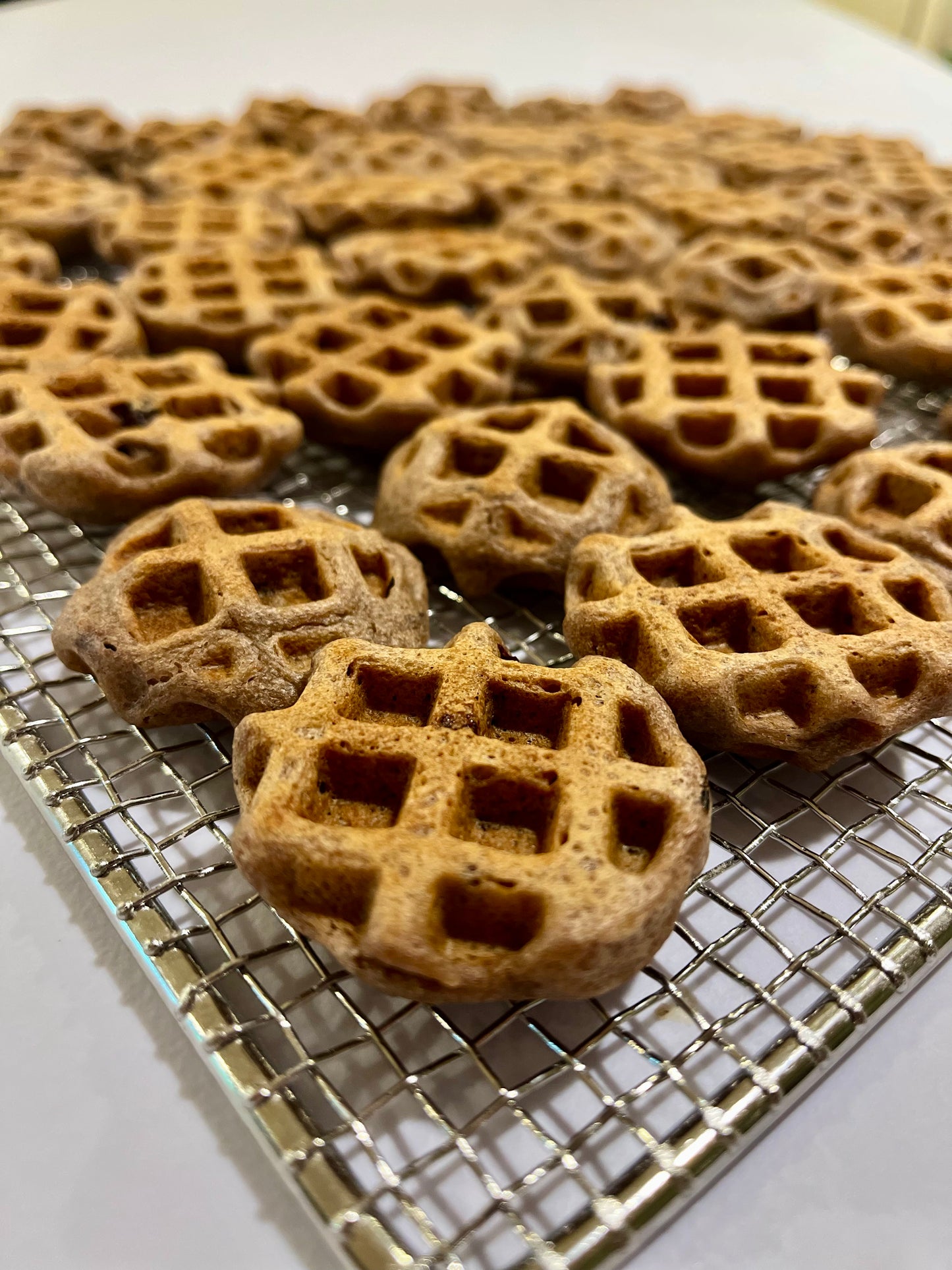 Fresh baked Ellie's Woofles dog treats cooling on wire rack - handmade waffle-shaped organic dog treats made in Montana