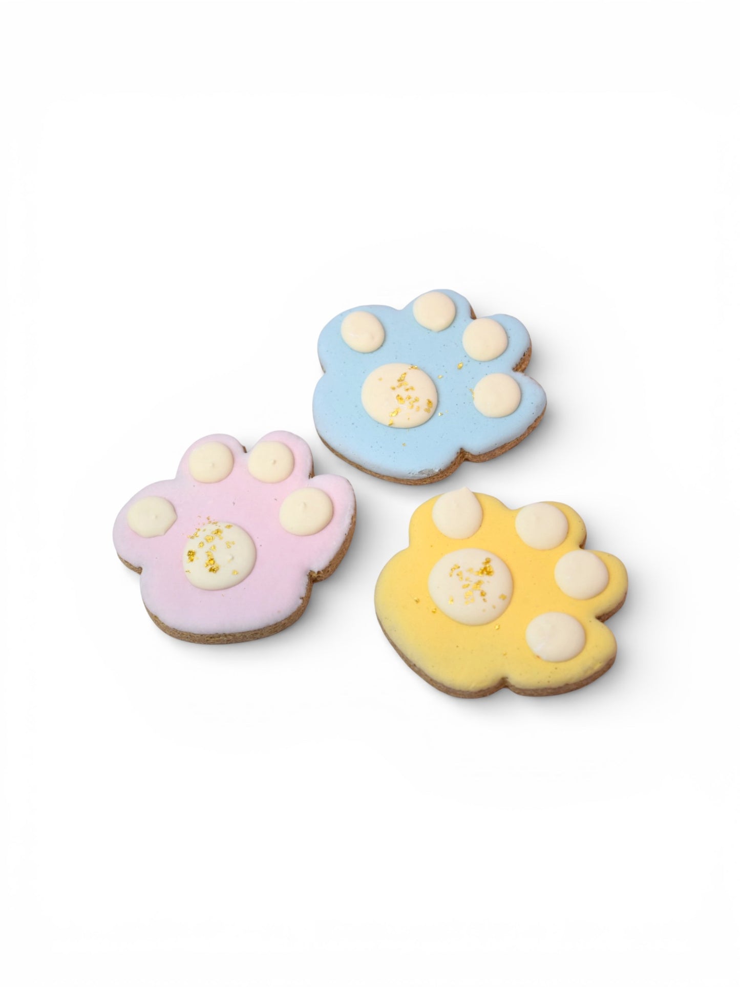 Hand-decorated spring paw print dog treats made in Montana with Big Prairie Peanut Butter, yogurt-based natural color icing, and 23-carat edible gold flakes.